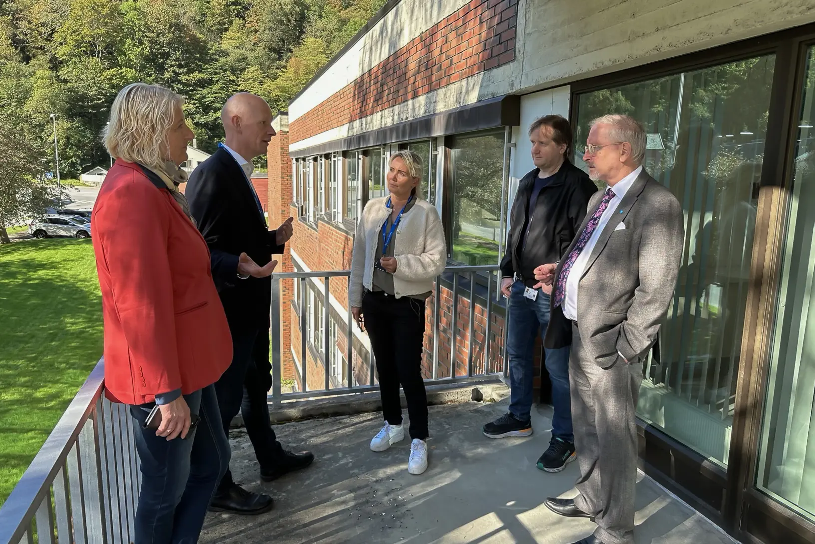 En gruppe mennesker som står utenfor en bygning