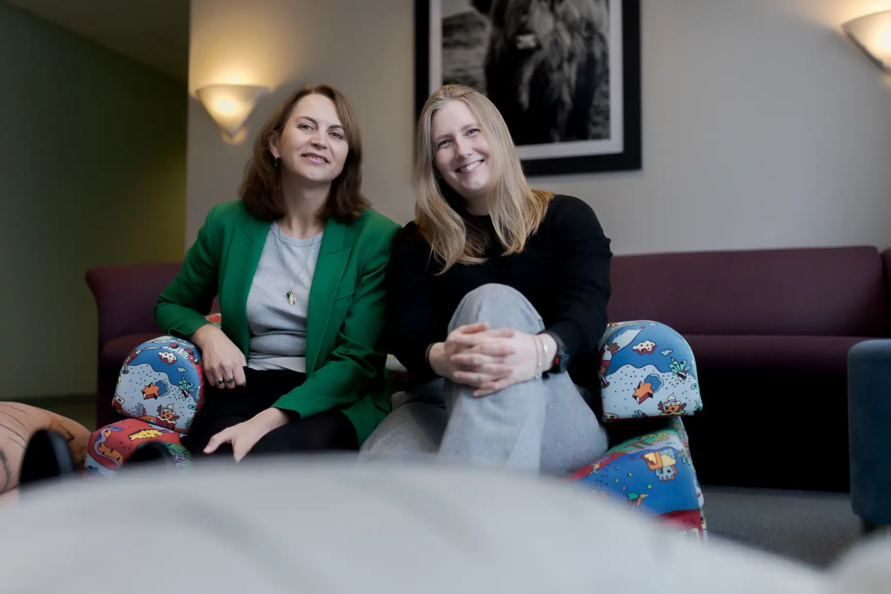 Et par kvinner som sitter på en sofa