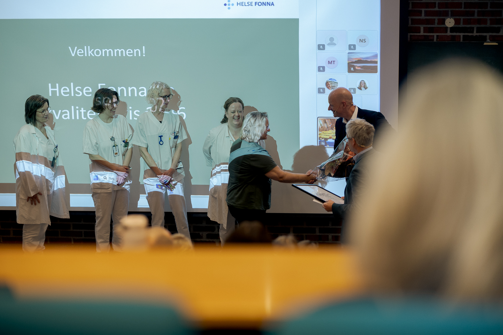 En gruppe mennesker som står foran en skjerm