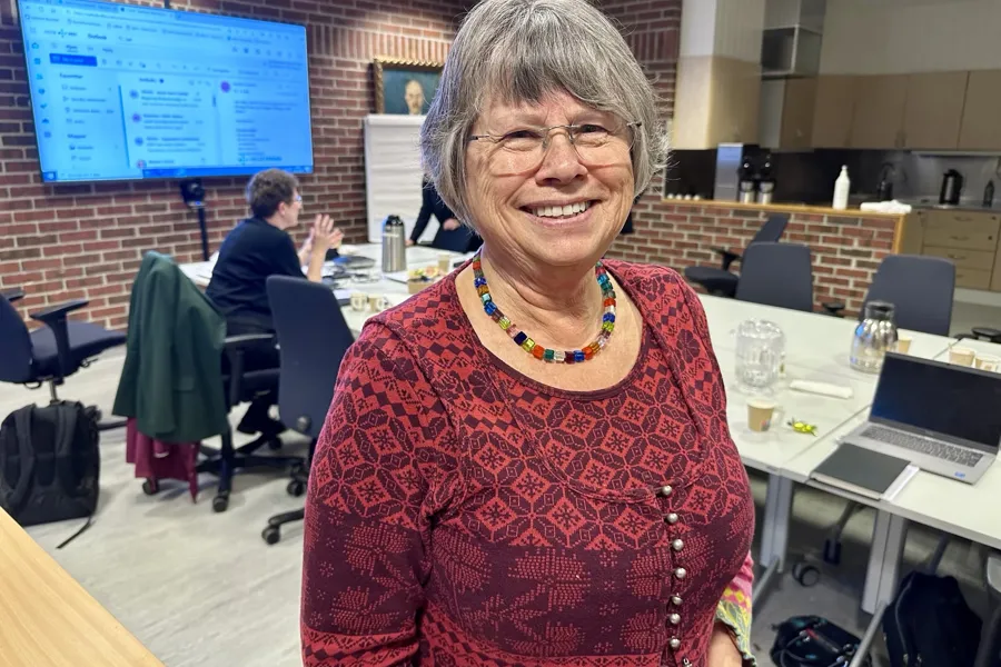 En kvinne som smiler til kameraet